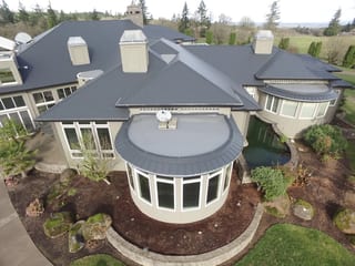 Deep Charcoal Interlock IB Membrane aluminum roof on a beige single-family home with a metal roof and large, Turner, Oregon