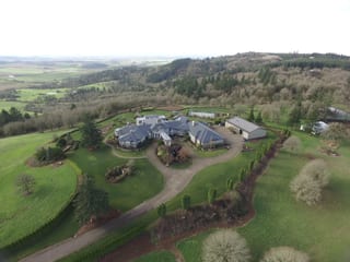 Deep Charcoal Interlock IB Membrane aluminum roof on a large modern home with a metal roof in a forested rural, Turner, Oregon