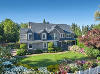 Deep Charcoal Interlock Shake aluminum roof on a two-storey colonial home with dormers among tall pines, Portland, Oregon