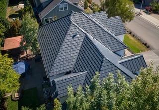 Deep Charcoal Interlock Shake aluminum roof on a grey two-storey home with a metal roof in a suburban, Portland, Oregon