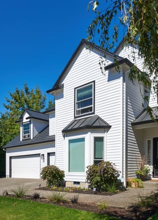 Deep Charcoal Interlock Shake aluminum roof on a white two-storey home with a metal roof in an urban, Portland, Oregon