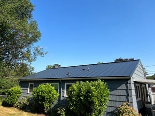 Black Interlock Standing Seam aluminum roof on a dark grey single-storey home with a metal roof in a, Portland, Oregon
