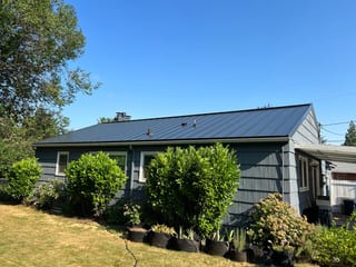 Black Interlock Standing Seam aluminum roof on a dark grey single-storey home with a black metal roof in, Portland, Oregon
