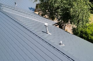 Deep Charcoal Interlock Slate aluminum roof on a single-family home with a metal roof in a forested area, Portland, Oregon