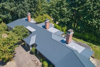 Deep Charcoal Interlock Slate aluminum roof on a single-storey home with a metal roof in a forested setting, Portland, Oregon