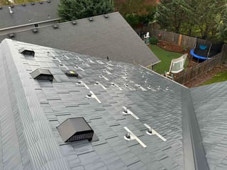 Deep Charcoal Interlock Cedar Shingle aluminum roof on a grey single-family home with a metal roof in a forested, Newberg, Oregon