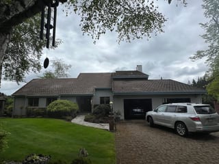 Before: a concrete tile roof with broken tiles on the home, Amity, Oregon, ahead of a Deep Charcoal Interlock Slate aluminum roof