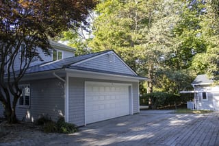 Deep Charcoal Interlock Slate aluminum roof on a colonial home in a wooded area with lush greenery, Warwick, Rhode Island