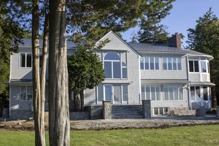 Deep Charcoal Interlock Slate aluminum roof on a two-storey colonial home with dormers among tall trees, Warwick, Rhode Island