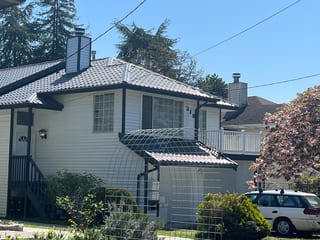 Charcoal Grey Interlock Tile aluminum roof on a white two-storey home with a metal roof in a suburban, Seattle, Washington
