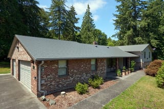 Musket Grey Interlock Cedar Shingle aluminum roof on a ranch-style home with a grey metal roof in a wooded area, Arlington, Washington