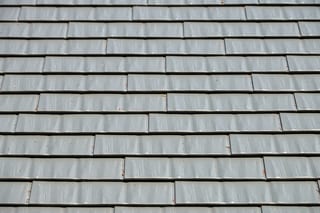 Musket Grey Interlock Cedar Shingle aluminum roof on a grey two-storey home with a metal roof in a suburban, Arlington, Washington