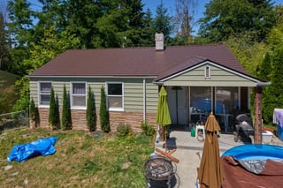 Colonial Brown Interlock Cedar Shingle aluminum roof on a Colonial-style home with a brown roof and green siding in, Shoreline, Washington