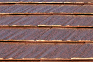 Aged Copper Interlock Cedar Shingle aluminum roof on a modern home with a metal roof in a lush green urban, Burien, Washington