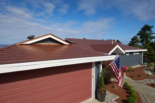 Aged Copper Interlock Cedar Shingle aluminum roof on a red two-storey home with a metal roof in a coastal, Burien, Washington