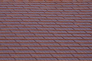 Aged Copper Interlock Cedar Shingle aluminum roof on a brown two-storey home with dormers in a suburban, Burien, Washington
