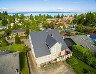 Musket Grey Interlock Slate aluminum roof on a two-storey cottage with dormers in a forested urban area, Seattle, Washington