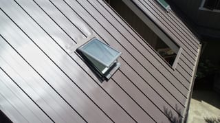 Tudor Brown Interlock Standing Seam aluminum roof on a brown home with a brown metal roof among tall trees, Fall City, Washington