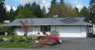 Deep Charcoal Interlock Slate aluminum roof on a white ranch style home with a metal roof in a forested, Marysville, Washington