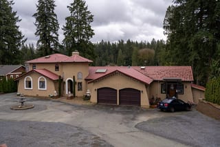 Tile Red Interlock Tile aluminum roof on a tan home with a red tile roof in a forest, Woodinville, Washington