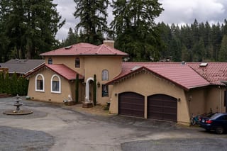 Tile Red Interlock Tile aluminum roof on a tan single-family home with a tile red metal roof in, Woodinville, Washington