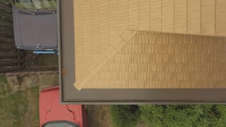 Aged Copper Interlock Cedar Shingle aluminum roof on a red house with a metal roof in a residential area, Bellevue, Washington