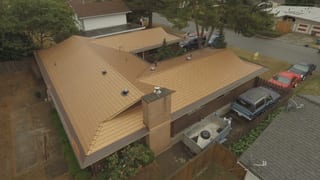 Aged Copper Interlock Cedar Shingle aluminum roof on a two-storey house with a metal roof and copper colour in a, Bellevue, Washington