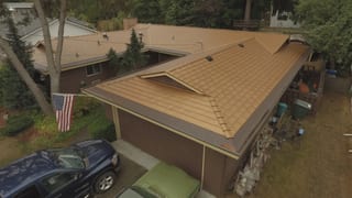 Aged Copper Interlock Cedar Shingle aluminum roof on a brown one-storey home with a hip roof in a suburban area, Bellevue, Washington