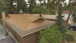 Aged Copper Interlock Cedar Shingle aluminum roof on a brown house with a metal roof in a forested suburban area, Bellevue, Washington