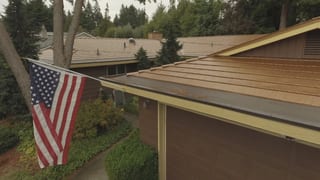 Aged Copper Interlock Cedar Shingle aluminum roof on a brown single-storey home with an overhanging eave among, Bellevue, Washington