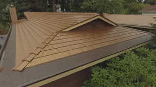 Aged Copper Interlock Cedar Shingle aluminum roof on a modern home with a metal roof among tall trees in the, Bellevue, Washington