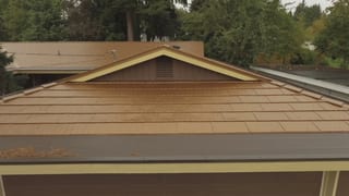 Aged Copper Interlock Cedar Shingle aluminum roof on a brown single-family home with a gable roof in a suburban, Bellevue, Washington