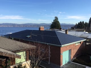 Black Interlock Slate aluminum roof on a brick house with a metal roof overlooking the ocean, Seattle, Washington