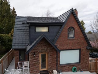 Deep Charcoal Interlock Shake aluminum roof on a red brick craftsman style home with a metal roof in a, Seattle, Washington