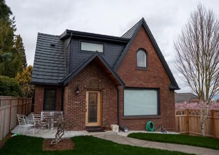Deep Charcoal Interlock Shake aluminum roof on a red brick home with a gable roof in a suburban setting, Seattle, Washington