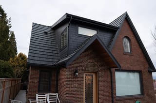 Deep Charcoal Interlock Shake aluminum roof on a red brick home with a metal roof in a suburban, Seattle, Washington