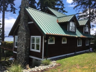 Before: a rusted metal roof on the home, Camano Island, Washington, ahead of a Musket Grey Interlock Standing Seam aluminum roof