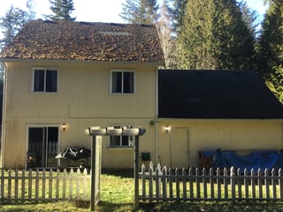 Before: a worn out asphalt shingle roof on the home, Poulsbo, Washington, ahead of a Black Interlock Slate aluminum roof