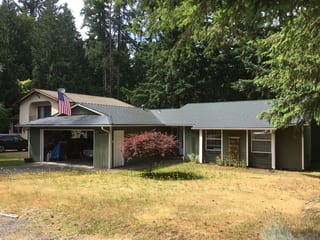 Deep Charcoal Interlock Slate aluminum roof on a two-storey home with a metal roof in a suburban forested, Renton, Washington