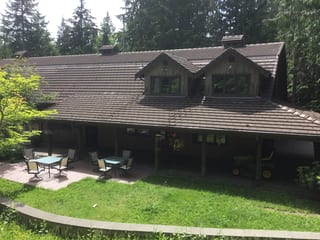Before: a concrete tile roof with broken tiles on the home, Preston, Washington, ahead of a Hunter Green Interlock Standing Seam aluminum roof
