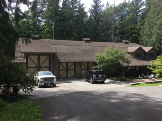 Before: a concrete tile roof with broken tiles on the home, Preston, Washington, ahead of a Hunter Green Interlock Standing Seam aluminum roof