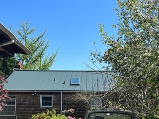 Hunter Green Interlock Standing Seam aluminum roof on a house with a green metal roof in a suburban neighbourhood, Seattle, Washington