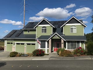 Deep Charcoal Interlock Slate aluminum roof on a two-storey home with green siding and dark roof in a, Marysville, Washington