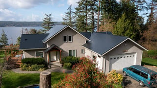 Black Interlock Slate aluminum roof on a modern house with a metal roof overlooking a lake and, Langley, Washington