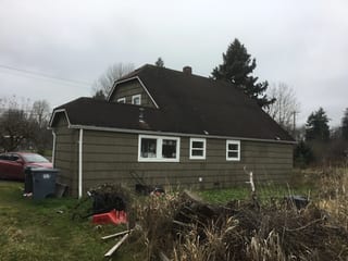 Before: a worn out asphalt shingle roof on the home, Tacoma, Washington, ahead of a Deep Charcoal Interlock Slate aluminum roof