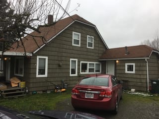 Before: a worn out asphalt shingle roof on the home, Tacoma, Washington, ahead of a Deep Charcoal Interlock Slate aluminum roof