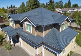 Deep Charcoal Interlock Tile aluminum roof on a two-storey home with dormers in a suburban forested, Lynnwood, Washington