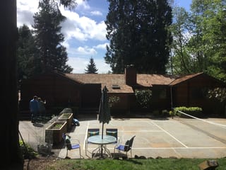Before: a worn out wood shake roof on the home, Bainbridge Island, Washington, ahead of a Copper Penny Interlock Shake aluminum roof