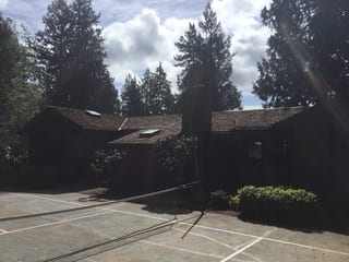 Before: a worn out wood shake roof on the home, Bainbridge Island, Washington, ahead of a Copper Penny Interlock Shake aluminum roof