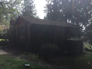 Before: a worn out wood shake roof on the home, Bainbridge Island, Washington, ahead of a Copper Penny Interlock Shake aluminum roof